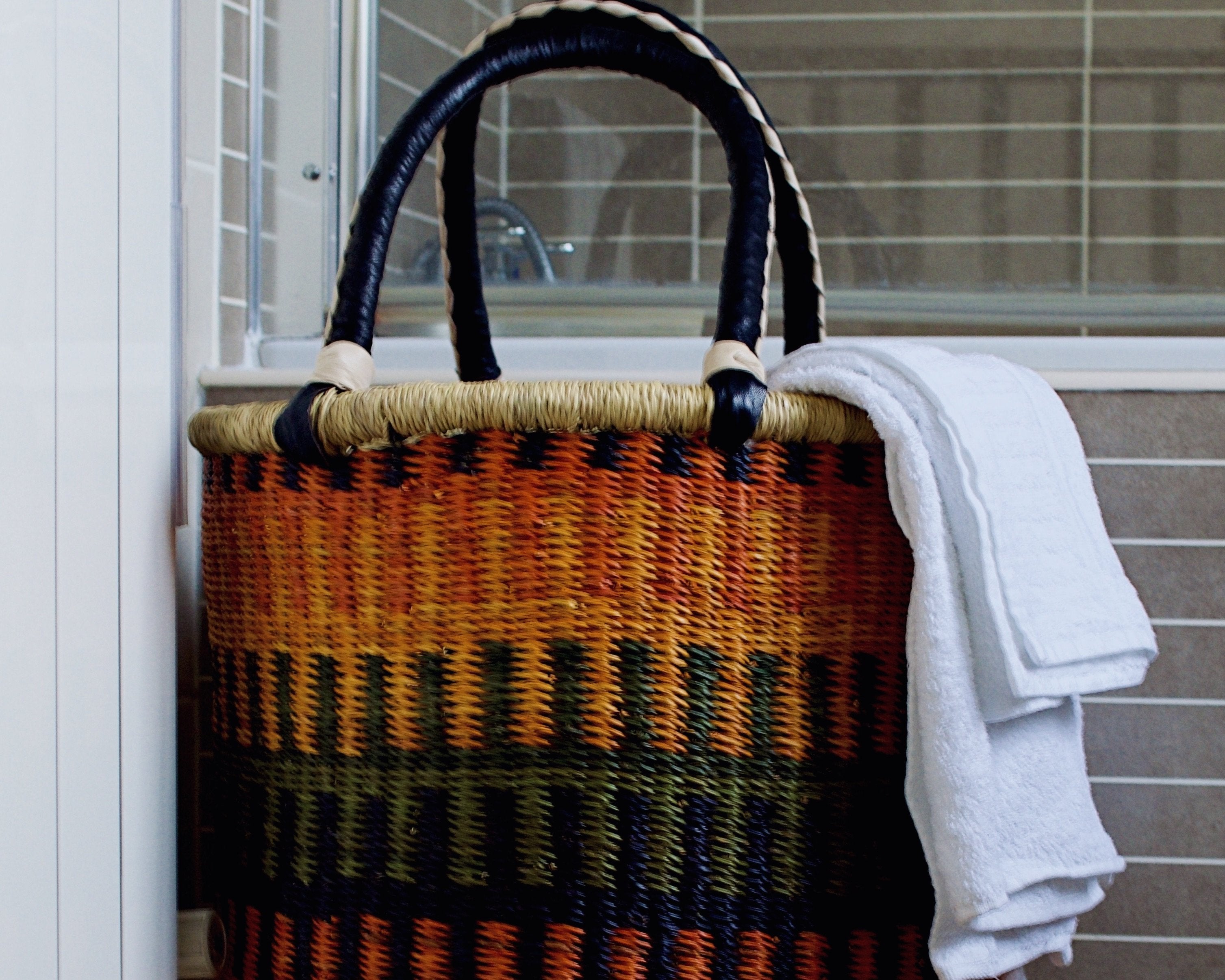 Colourful handwoven laundry basket placed in bathroom